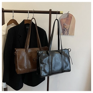 Detail minimalistischer Tragetaschen in Schwarz und Braun mit Kordelzug-Akzenten