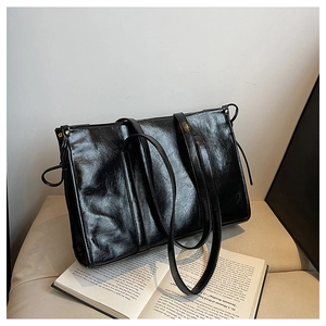 Detailansicht der schwarzen glänzenden Leder-Tote-Bag mit Vintage-Textur und Knotendetails