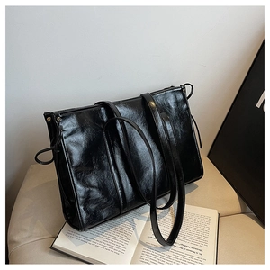 Detailansicht der schwarzen Shopper-Tasche aus glänzendem Öl-Wachs-Leder mit Kordelzug