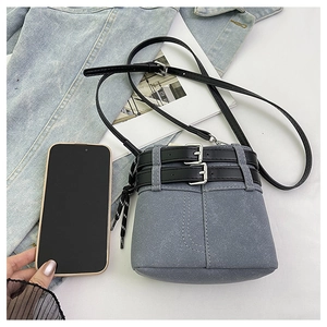 Dettaglio mini borsa a secchiello in pelle scamosciata grigia con fibbie e coulisse