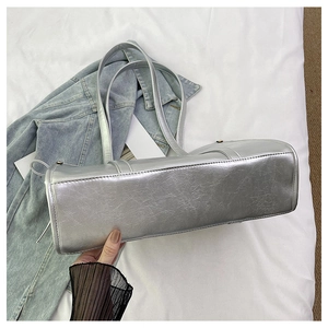 Detailansicht einer silbernen Metallic-Tasche mit strukturierter Kunstleder-Optik