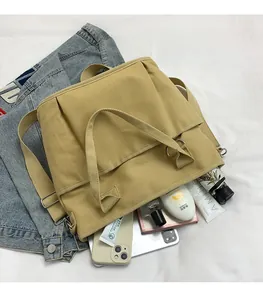 Detail of khaki canvas tote bag showing large capacity for phone and cosmetics