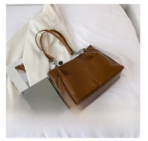 Detail showing dark brown leather tote bag capacity compared with a tablet on white background
