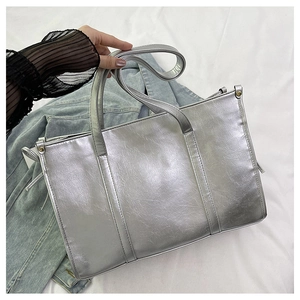 Detail der glänzenden silbernen Metallic-Textur und Nieten an dieser großen Tote Bag