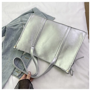 Detail der silbernen Metallic-Tasche mit Faltenstruktur und schicken Metallnieten-Akzenten