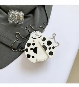 Detail view of the ladybug round bag with black polka dots and silver metal chain