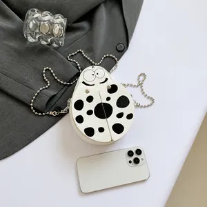 Mini cartoon ladybug crossbody bag shown with a smartphone for precise size reference