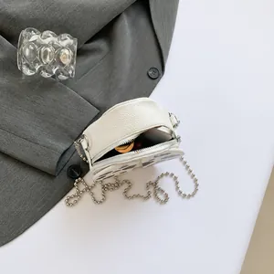 Detail view of white cow pattern crossbody bag showing internal space for phone and lipstick