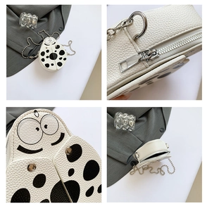 Detail view of ladybug crossbody bag with white lychee grain leather and silver chain