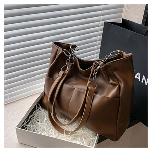 Detailed top view of a large brown tote bag with premium matte leather texture and fine stitching