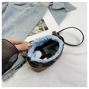 Vista dall'alto di una borsa a secchiello scamosciata marrone con trucco e coulisse