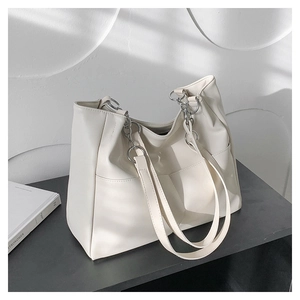 Detail view of the large off-white tote bag featuring soft leather texture and metal chain