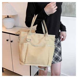 Detail view of thickened canvas tote bag with functional exterior pockets and shoulder strap