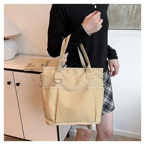 Detail of khaki canvas tote with multiple pockets and durable shoulder strap hardware