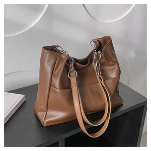 Detail of soft brown PU leather tote bag featuring a front pocket and silver metal rings