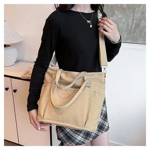 Close-up of beige canvas tote bag showing thick fabric texture and outer pockets