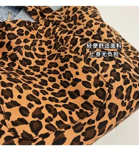 Detail view of leopard print canvas tote bag showing twill fabric texture and front pocket