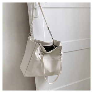 Detail of white PU leather tote bag featuring metal chain accents and large capacity