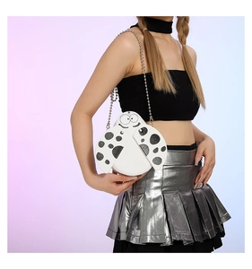 Detail of white ladybug crossbody bag featuring black dots and silver bead chain strap