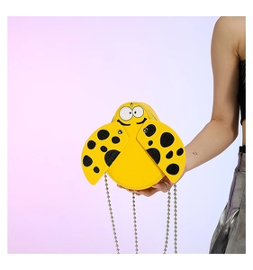 Close-up of yellow ladybug cartoon kids crossbody bag with black dots and bead chain