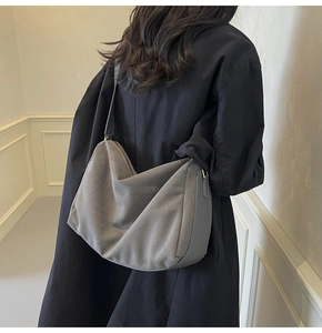 Detailed macro view of gray suede hobo bag texture and wide shoulder strap seam