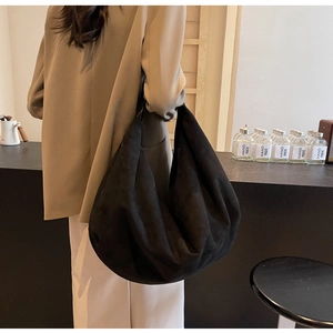 Detailed view of a black suede hobo bag featuring natural drape and large capacity