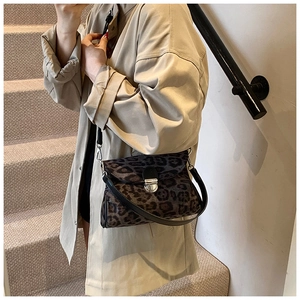 Chic leopard print crossbody bag styled with an autumn coat on a staircase