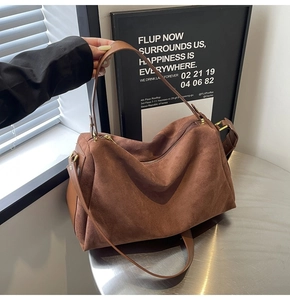 Detailed macro view of brown suede texture and golden metal zipper on the shoulder bag