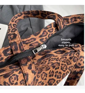 Close-up of a smooth black zipper and silver metal puller on a leopard print tote bag