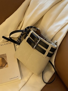 Elegante borsa a secchiello in tela beige con cinturini neri e chiusura a coulisse