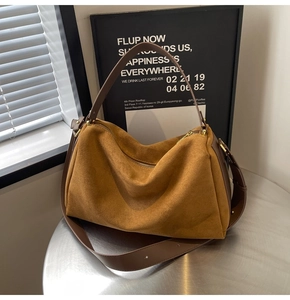 Detail of vintage brown suede baguette bag with leather trim and gold metal zipper