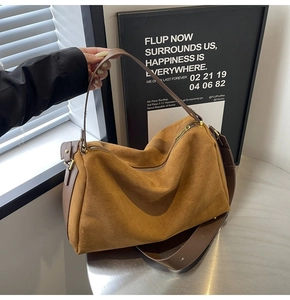 Detailed macro view of the brown suede surface and golden zipper hardware on the bag