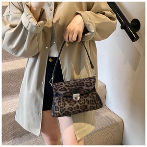 Detailed view of leopard print small square bag with silver metal lock on a model