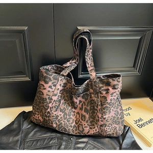 Detail of leopard print tote bag with functional front pocket and purple canvas texture