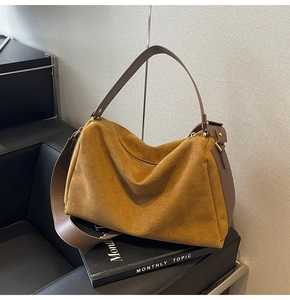 Detail of retro suede baguette bag with contrasting leather straps on a vintage chair