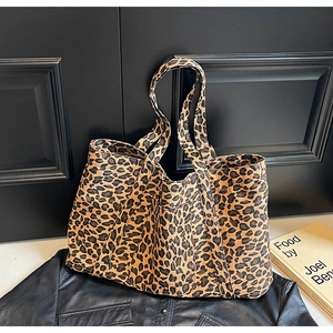 Detail of leopard print tote bag with large front pocket on textured background