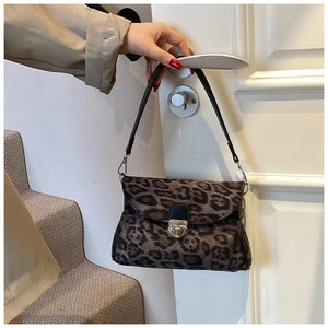 Detail of leopard print handbag with silver metal turn-lock and black shoulder strap