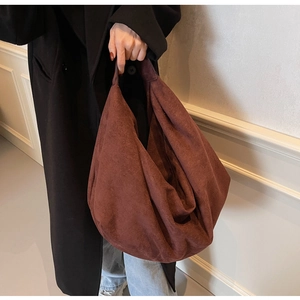Close-up of a large suede tote bag in caramel brown with a vintage hobo silhouette