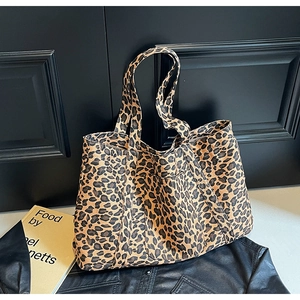 Detailed view of large leopard print tote bag with functional front pocket and wide handles