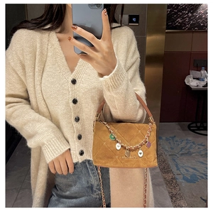 Caramel quilted suede handbag with colorful charms and chain strap shown in a mirror selfie