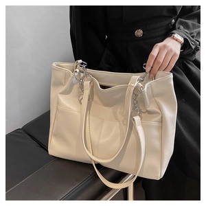 Detail of soft cream PU leather tote bag featuring stylish chain shoulder straps