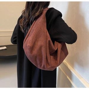 Detail view of a large brick red suede tote bag showing its slouchy minimalist design