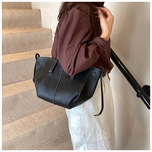 Détail d'un sac cabas en cuir grainé noir avec des coutures contrastées blanches