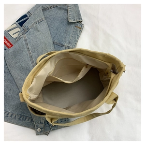 Detailed top view of beige canvas tote bag showing interior lining and zipper pocket