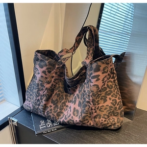 Detail showing the thick canvas texture and leopard print pattern on the tote bag