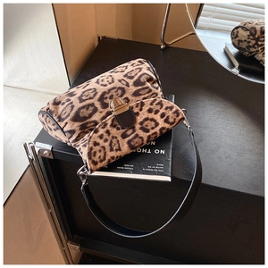 Detail view of leopard print crossbody bag with gold metal buckle and black leather strap