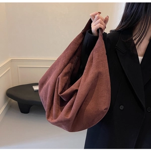 Detailed view of spacious reddish brown suede hobo bag with inner zipper pocket