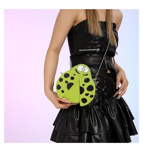 Detail view of ladybug-shaped mini bag with green PU leather and black polka dots