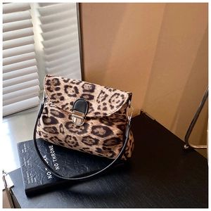 Close-up of leopard print crossbody bag with silver buckle and black leather strap detail