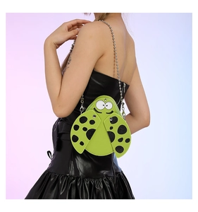 Detail of green ladybug crossbody bag with black polka dots and silver ball chain strap